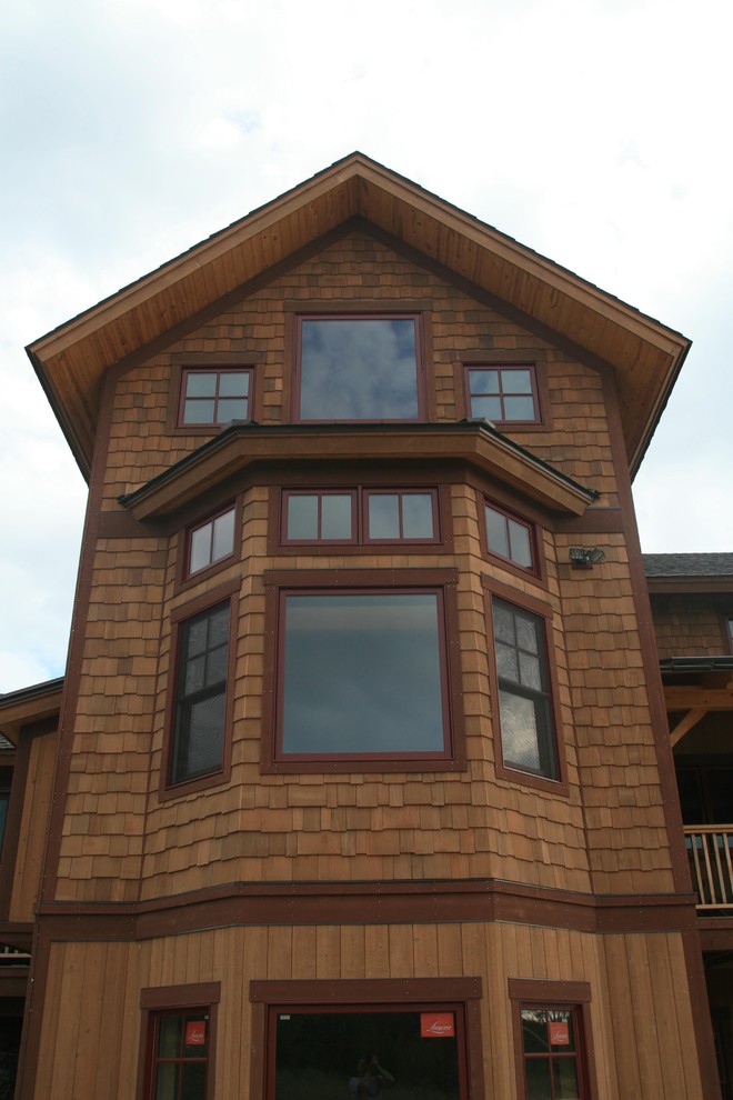 Diseño de fachada marrón clásica de tamaño medio de dos plantas con revestimiento de madera y tejado a dos aguas