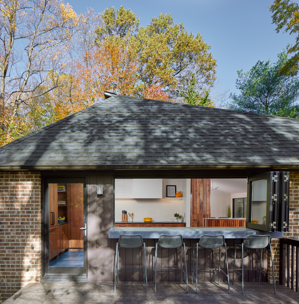 Cette image montre une façade de maison marron vintage en brique avec un toit à quatre pans et un toit en shingle.