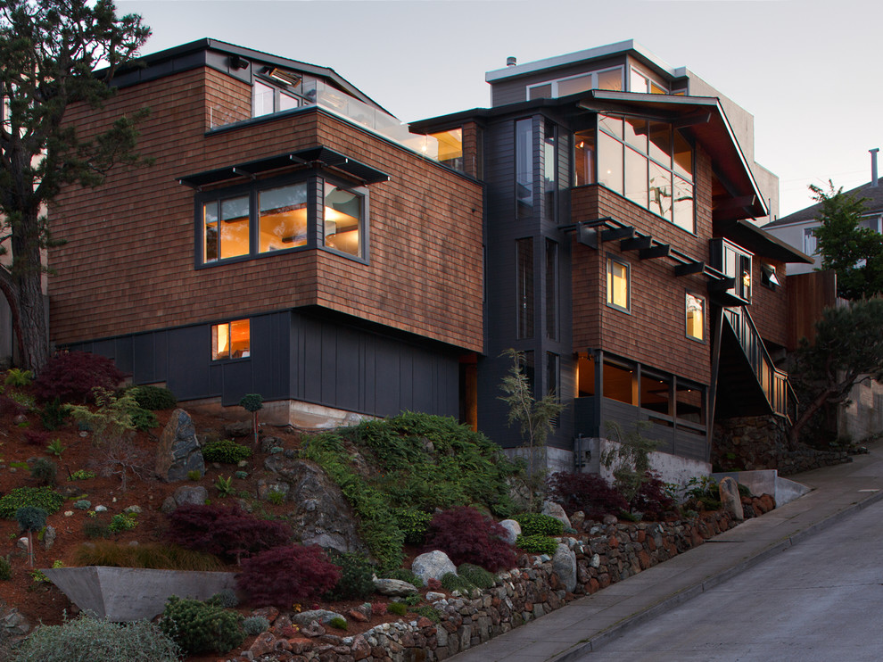 Стильный дизайн: коричневый, большой, двухэтажный, деревянный дом в современном стиле с двускатной крышей - последний тренд