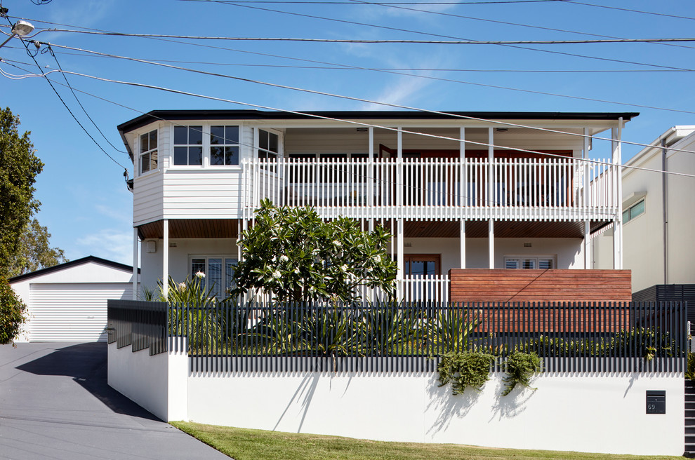 Imagen de fachada de casa blanca contemporánea de dos plantas con revestimientos combinados