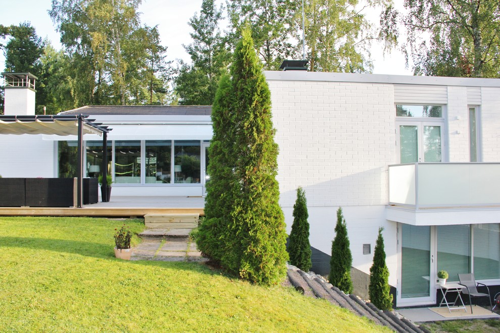 Immagine della facciata di una casa bianca moderna a due piani con rivestimento in mattoni