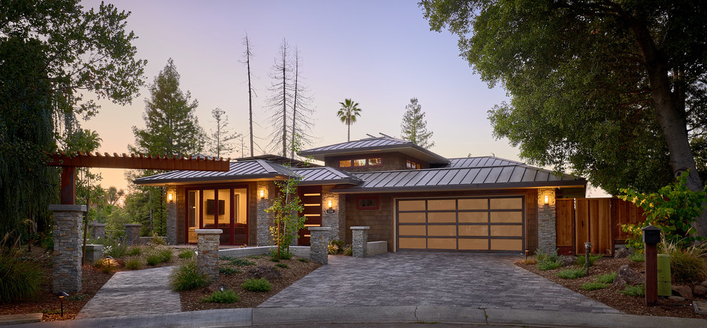 На фото: большой, двухэтажный, коричневый частный загородный дом в стиле рустика с вальмовой крышей, металлической крышей и комбинированной облицовкой