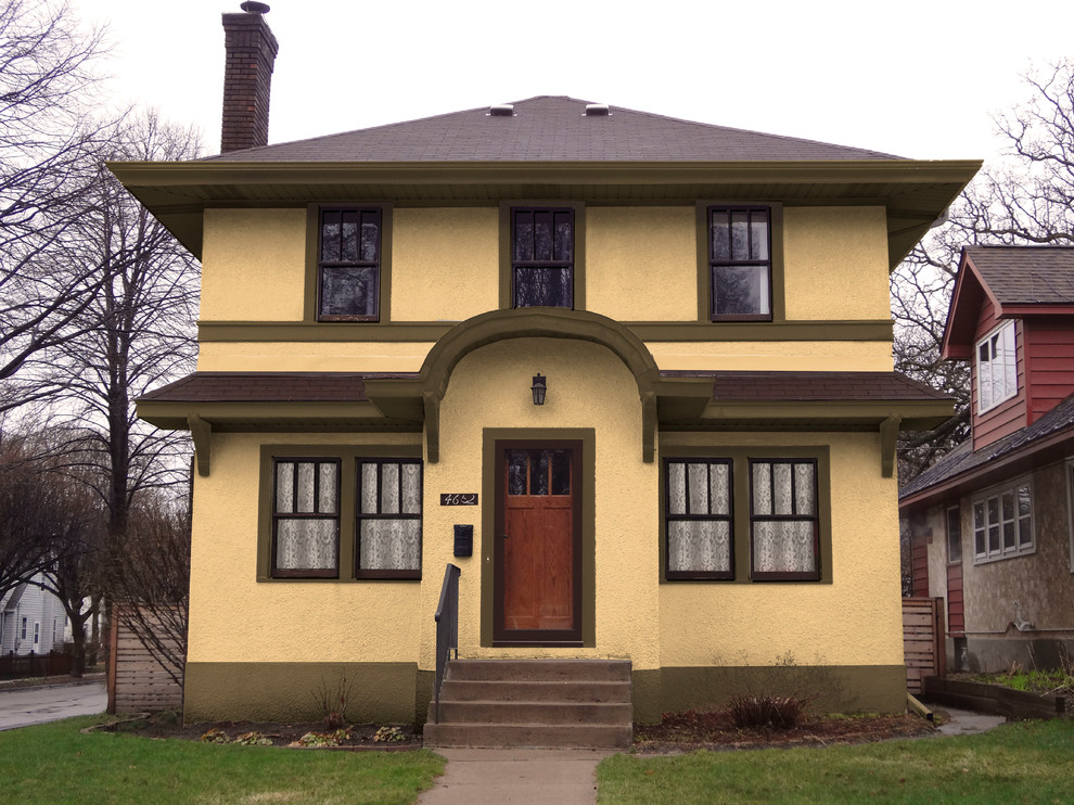Inspiration för mellanstora amerikanska gula hus, med två våningar, stuckatur och valmat tak