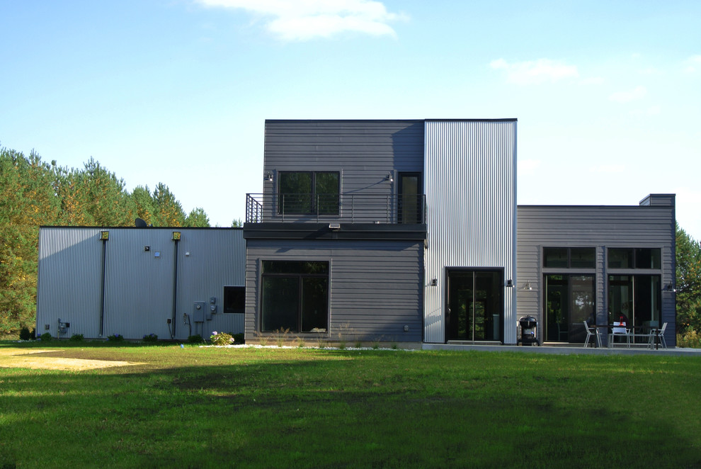 Inspiration för ett mellanstort funkis grått hus, med två våningar, metallfasad och platt tak