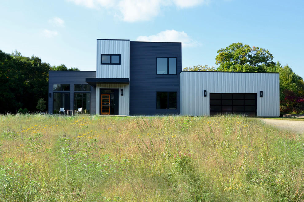 На фото: двухэтажный, серый дом среднего размера в стиле модернизм с облицовкой из металла и плоской крышей