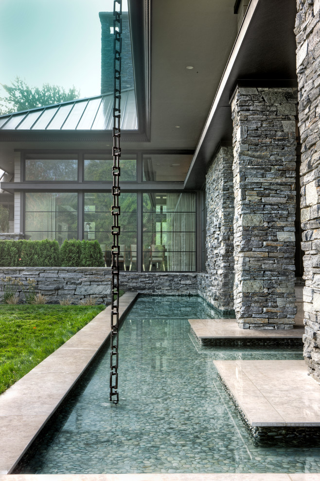 Modelo de fachada de casa gris minimalista grande de dos plantas con revestimiento de piedra, tejado a dos aguas y tejado de metal