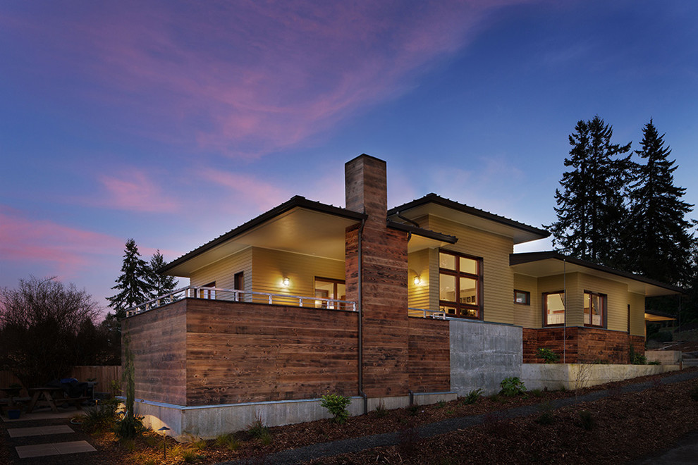 Mittelgroßes, Einstöckiges Modernes Einfamilienhaus mit Mix-Fassade, gelber Fassadenfarbe, Flachdach und Blechdach in Seattle
