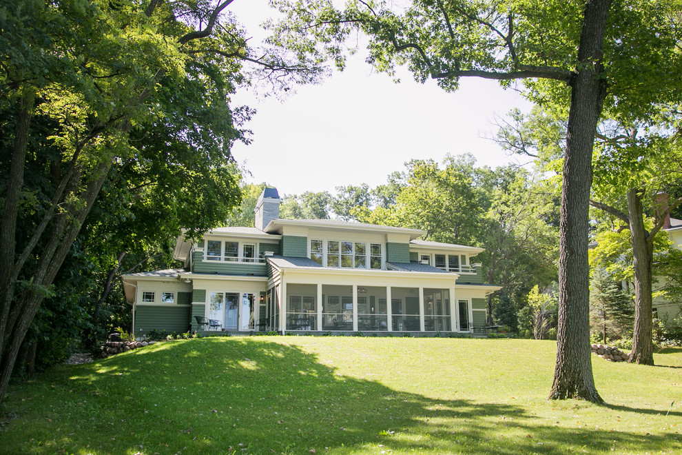 Ejemplo de fachada de casa verde de estilo americano grande de dos plantas con revestimiento de madera, tejado a cuatro aguas y tejado de teja de madera