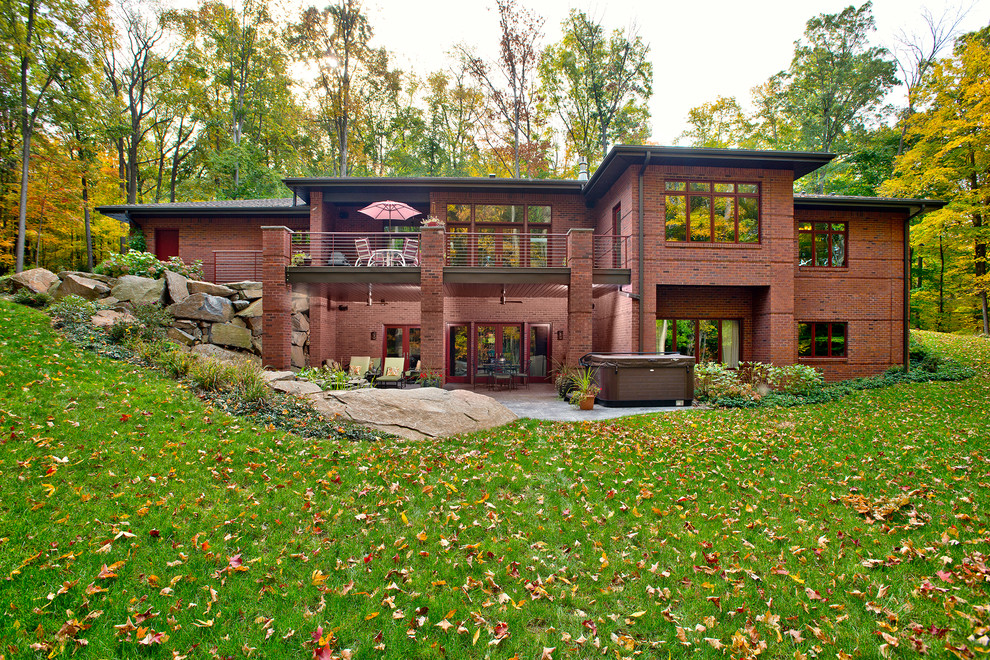 Esempio della facciata di una casa grande rossa american style a due piani con rivestimento in mattoni e tetto a padiglione