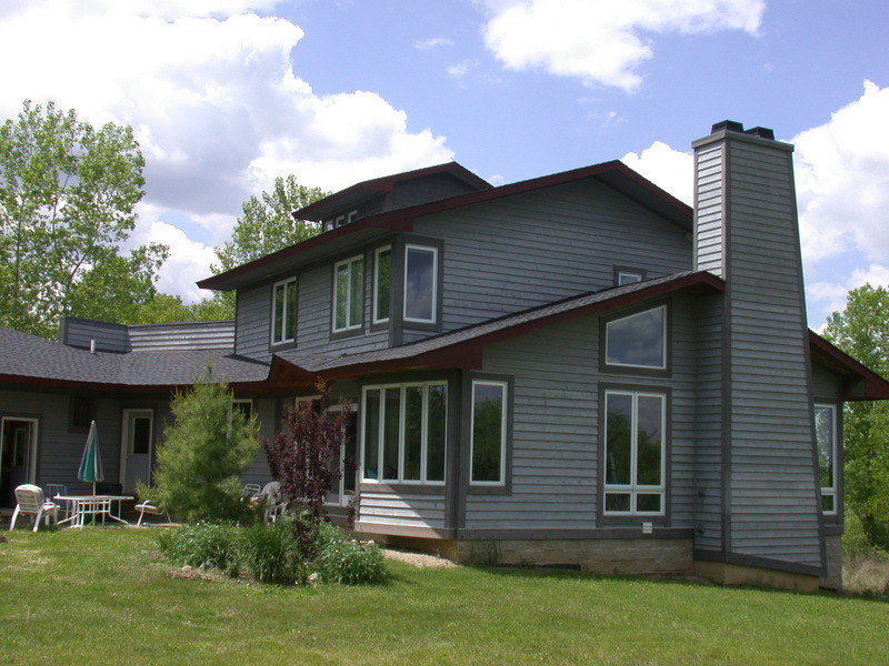 Imagen de fachada gris clásica renovada de tamaño medio de dos plantas con revestimiento de madera