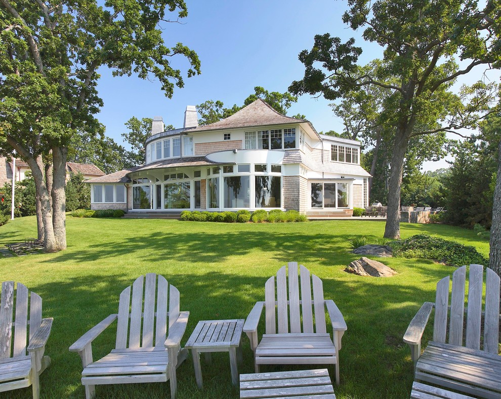 Idee per la villa ampia beige stile marinaro a due piani con rivestimento in legno, tetto a padiglione e copertura a scandole
