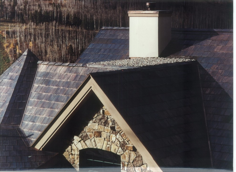 Foto della facciata di una casa grande beige rustica a due piani con rivestimenti misti e copertura in metallo o lamiera