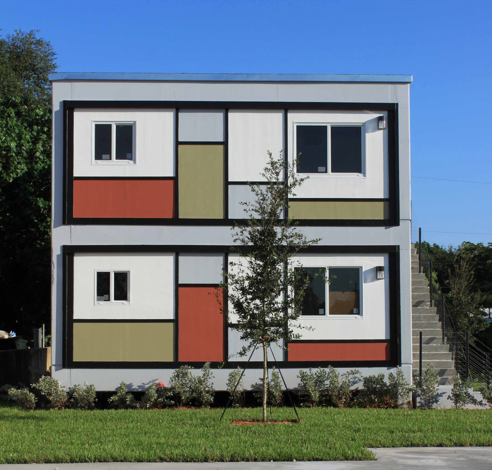 Modelo de fachada minimalista de tamaño medio de dos plantas con revestimiento de vinilo y tejado plano