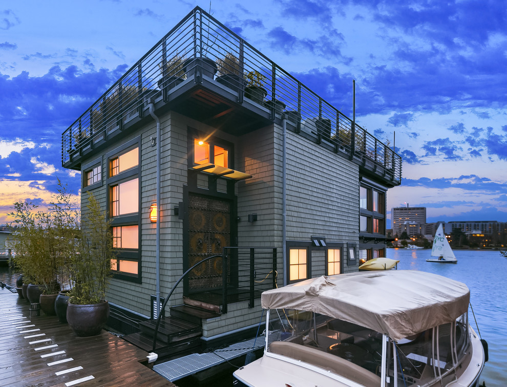 Стильный дизайн: двухэтажный, серый частный загородный дом в стиле фьюжн с плоской крышей - последний тренд