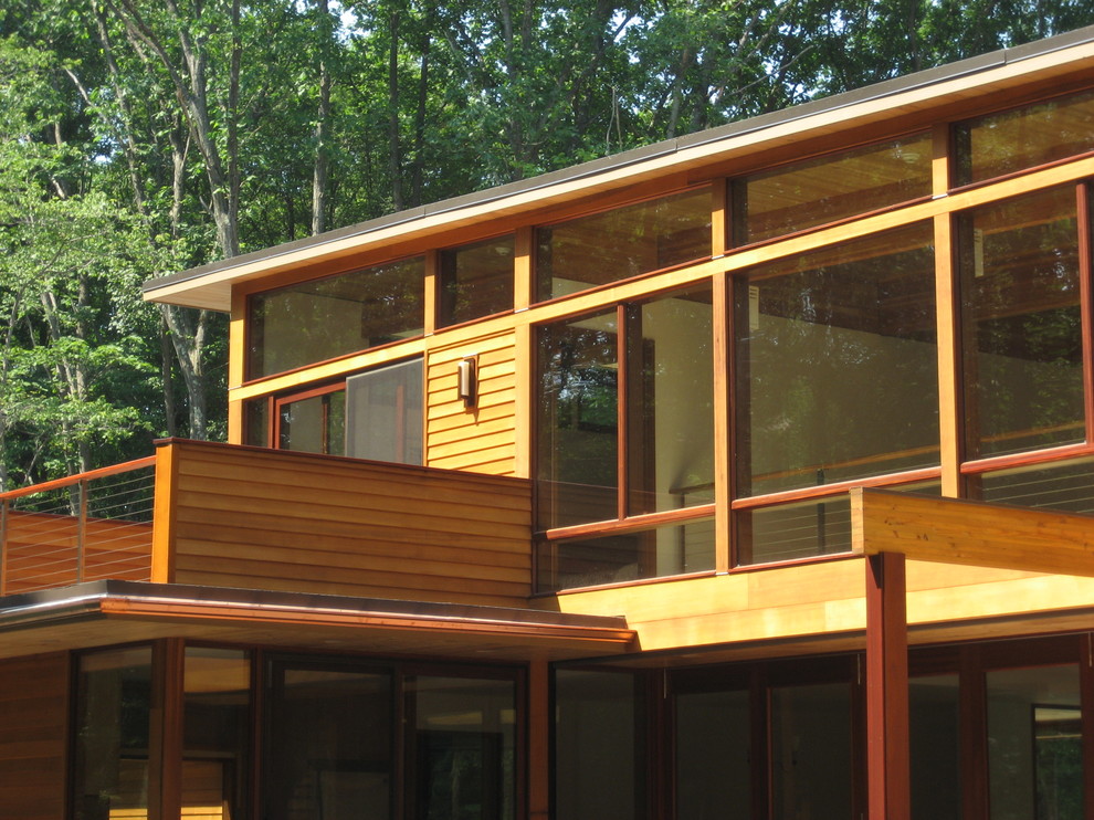 Diseño de fachada de casa contemporánea grande de dos plantas con revestimiento de madera y tejado plano