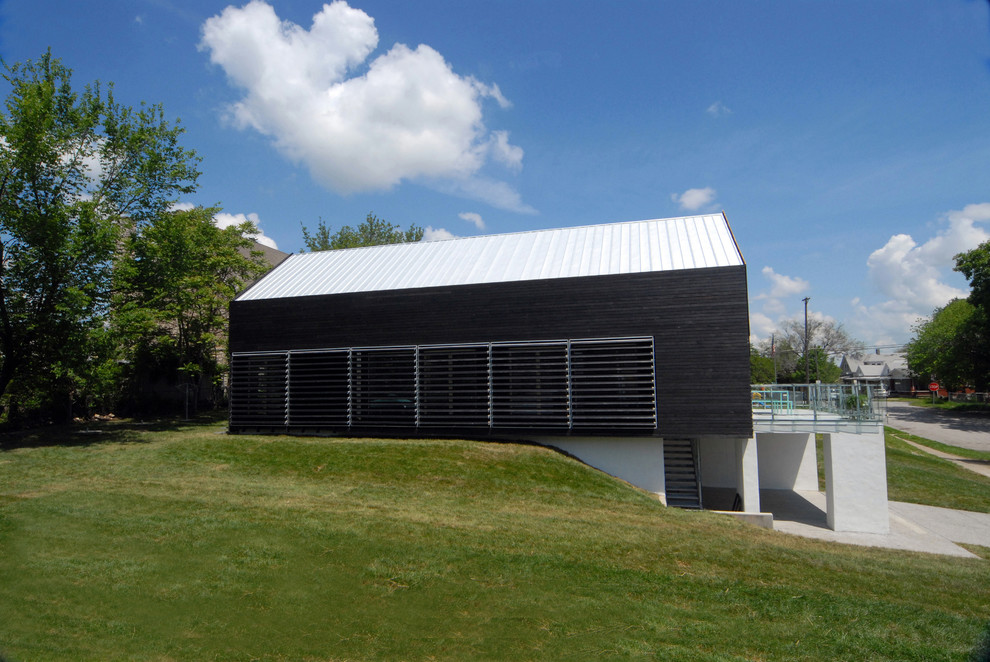 Imagen de fachada negra moderna de tamaño medio de dos plantas con revestimiento de madera y tejado a dos aguas
