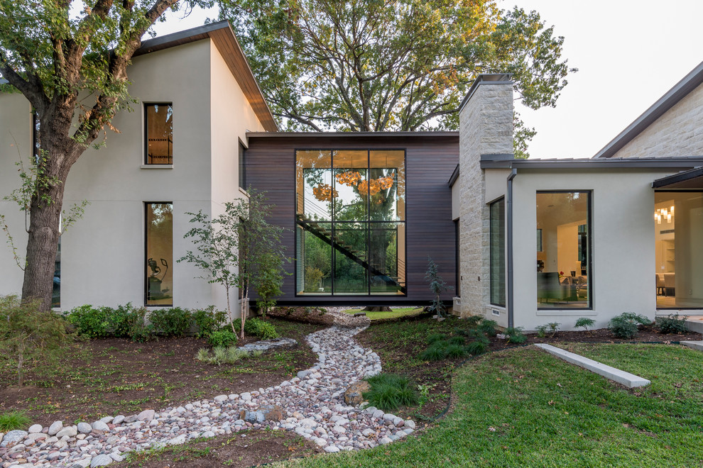 Photo of a large and beige contemporary two floor house exterior in Dallas with mixed cladding and a lean-to roof.