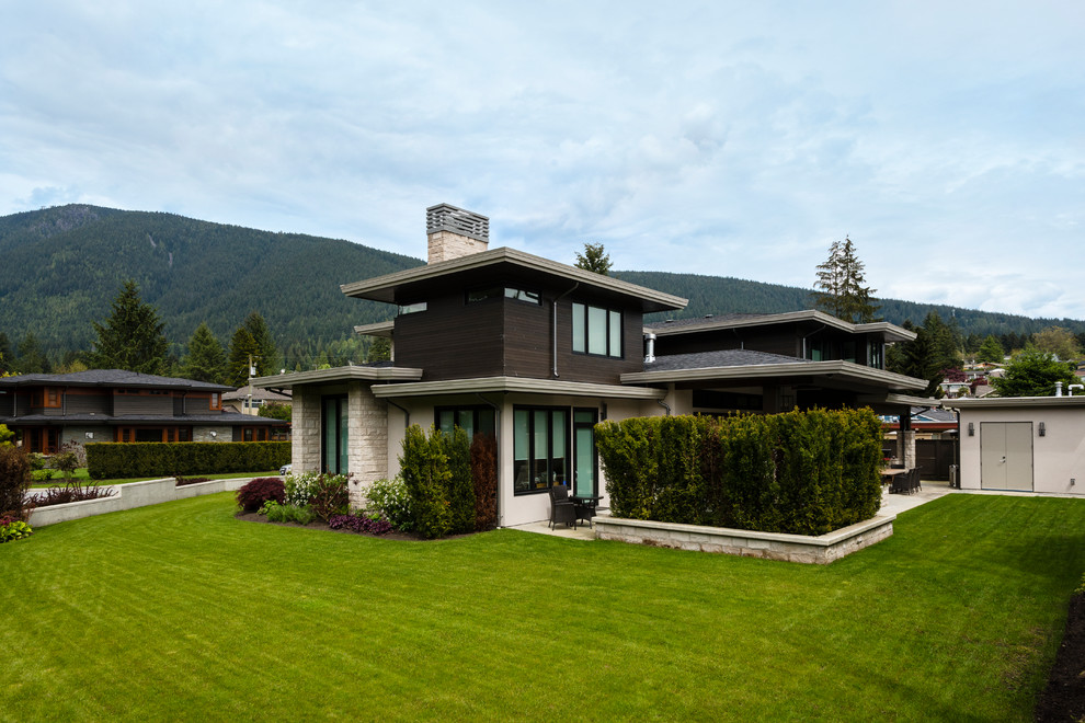 Example of a mid-sized trendy brown two-story brick exterior home design in Vancouver with a shingle roof