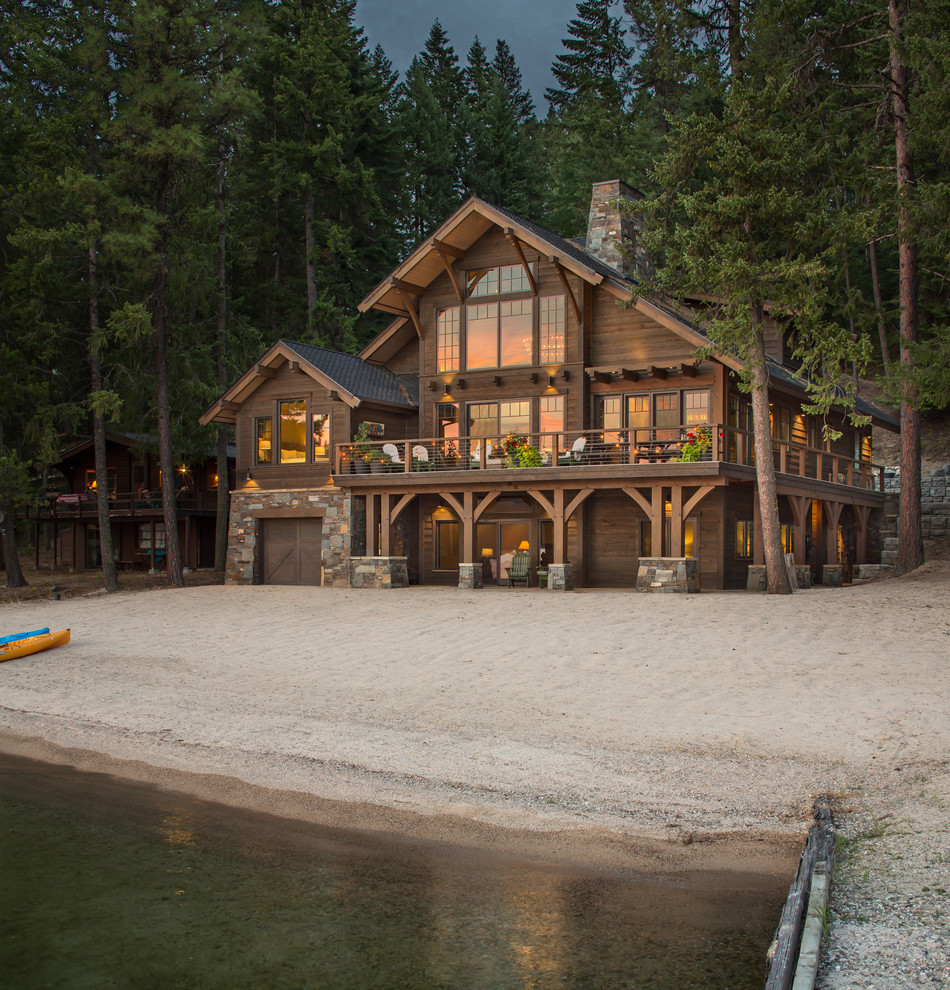 Foto della villa marrone rustica a due piani con rivestimento in legno e tetto a capanna