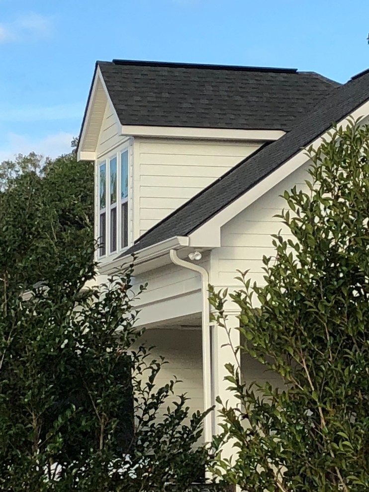 Großes, Zweistöckiges Landhausstil Einfamilienhaus mit Faserzement-Fassade, beiger Fassadenfarbe, Satteldach und Schindeldach in New Orleans