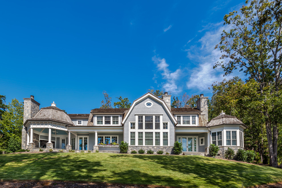 Ispirazione per la villa blu stile marinaro a due piani con tetto a mansarda, copertura a scandole e rivestimento in legno
