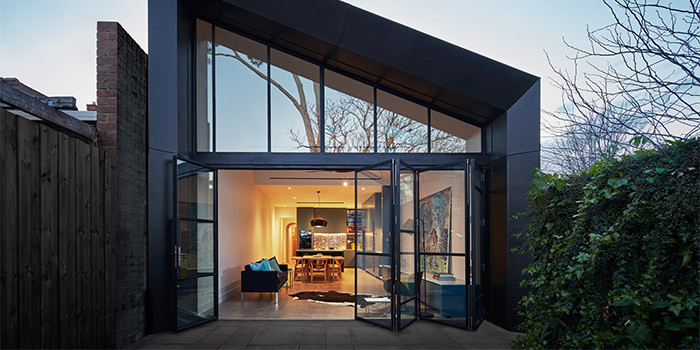 Foto della villa nera contemporanea a due piani di medie dimensioni con rivestimento in metallo, tetto a capanna e copertura in metallo o lamiera