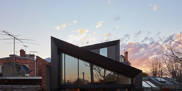 Mittelgroßes, Zweistöckiges Modernes Einfamilienhaus mit schwarzer Fassadenfarbe, Metallfassade, Satteldach und Blechdach in Melbourne