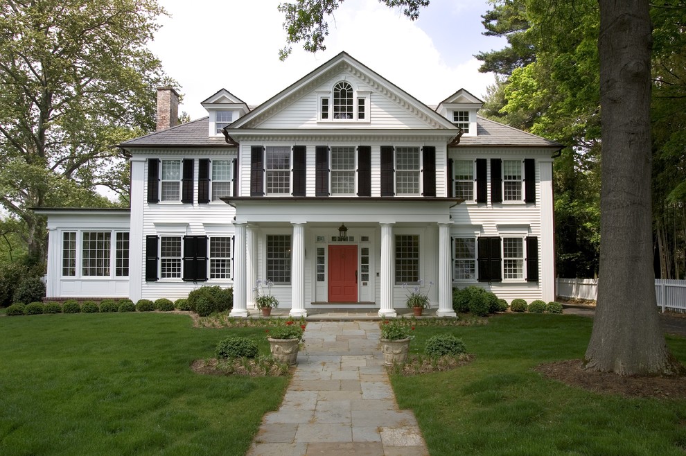 Стильный дизайн: большой, трехэтажный, деревянный, белый дом в классическом стиле с двускатной крышей - последний тренд