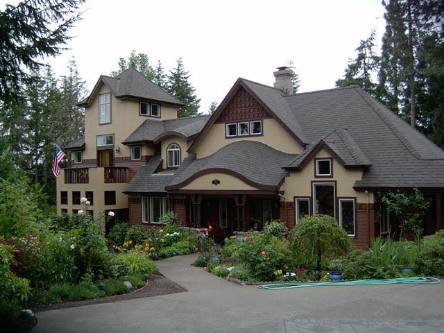 Cette photo montre une grande façade de maison beige craftsman à deux étages et plus avec un revêtement mixte, un toit à quatre pans et un toit en tuile.