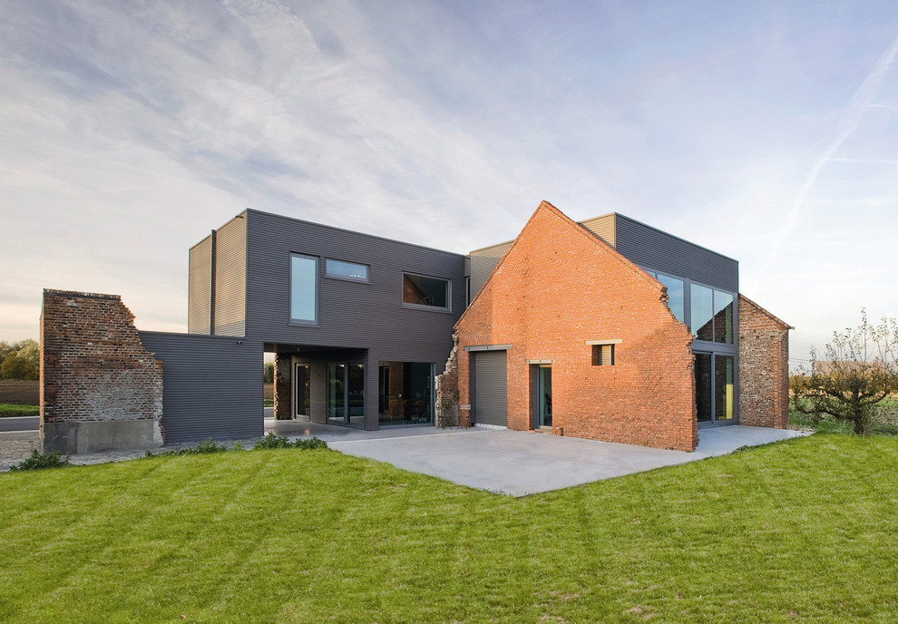 Réalisation d'une façade de maison grise design à un étage avec un toit plat.