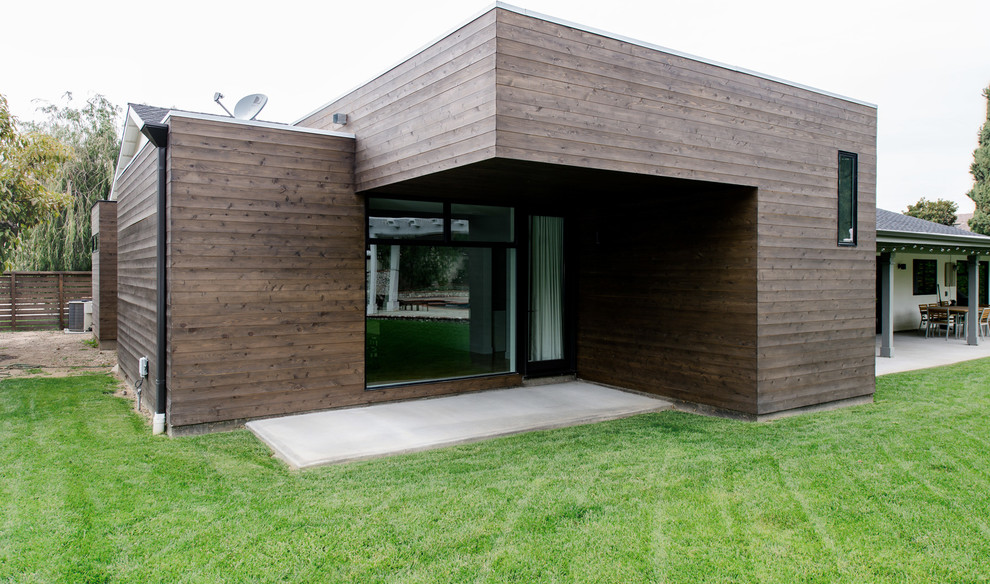 Idée de décoration pour une grande façade de maison marron minimaliste en bois de plain-pied avec un toit plat.