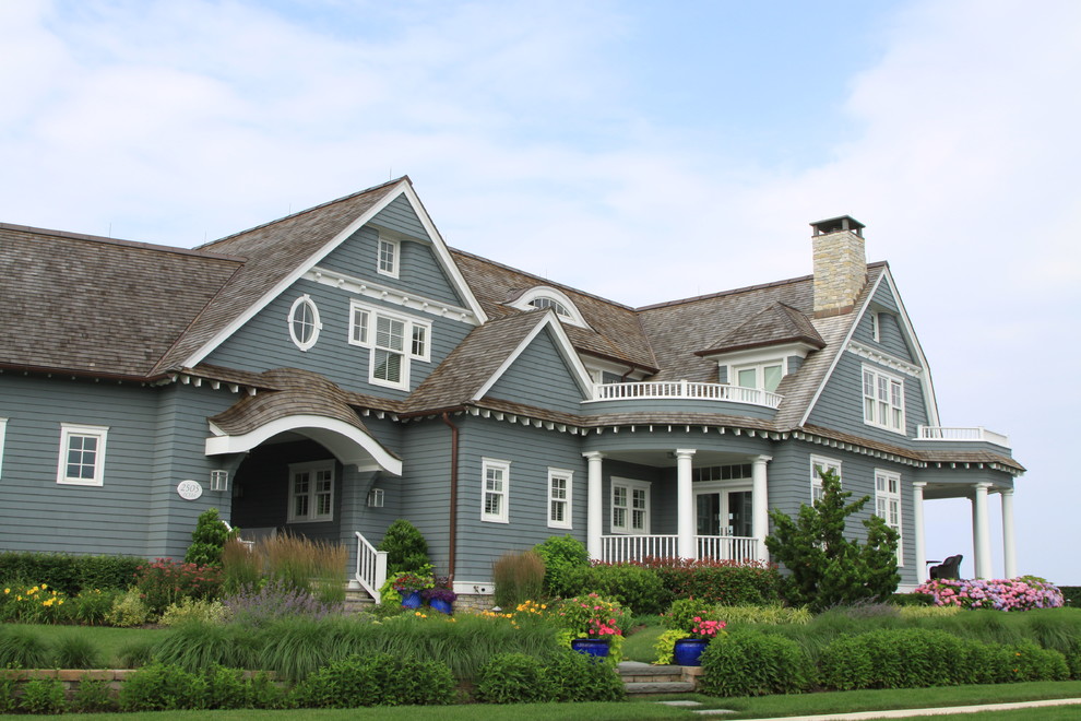 Inspiration pour une grande façade de maison bleue marine en bois à un étage.