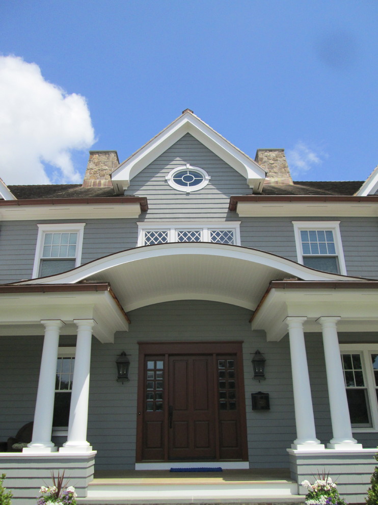Foto della facciata di una casa blu classica a due piani con rivestimento in legno