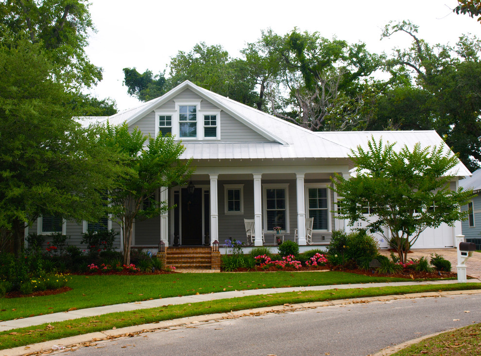 Cette image montre une façade de maison grise traditionnelle de taille moyenne et de plain-pied avec un revêtement en vinyle et un toit à quatre pans.