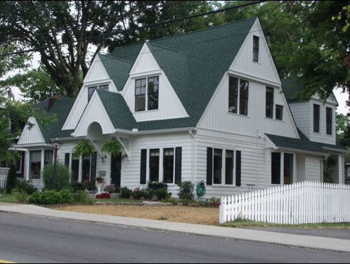 На фото: двухэтажный, деревянный, белый дом среднего размера в стиле неоклассика (современная классика) с двускатной крышей