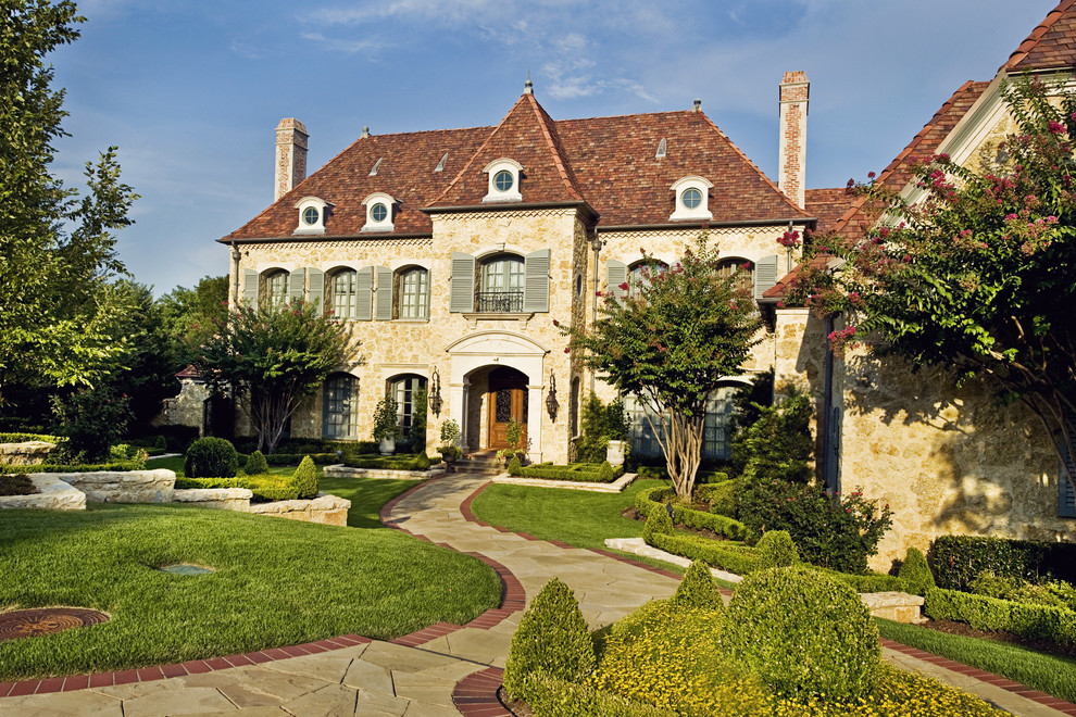 Example of a french country two-story stone exterior home design in Dallas