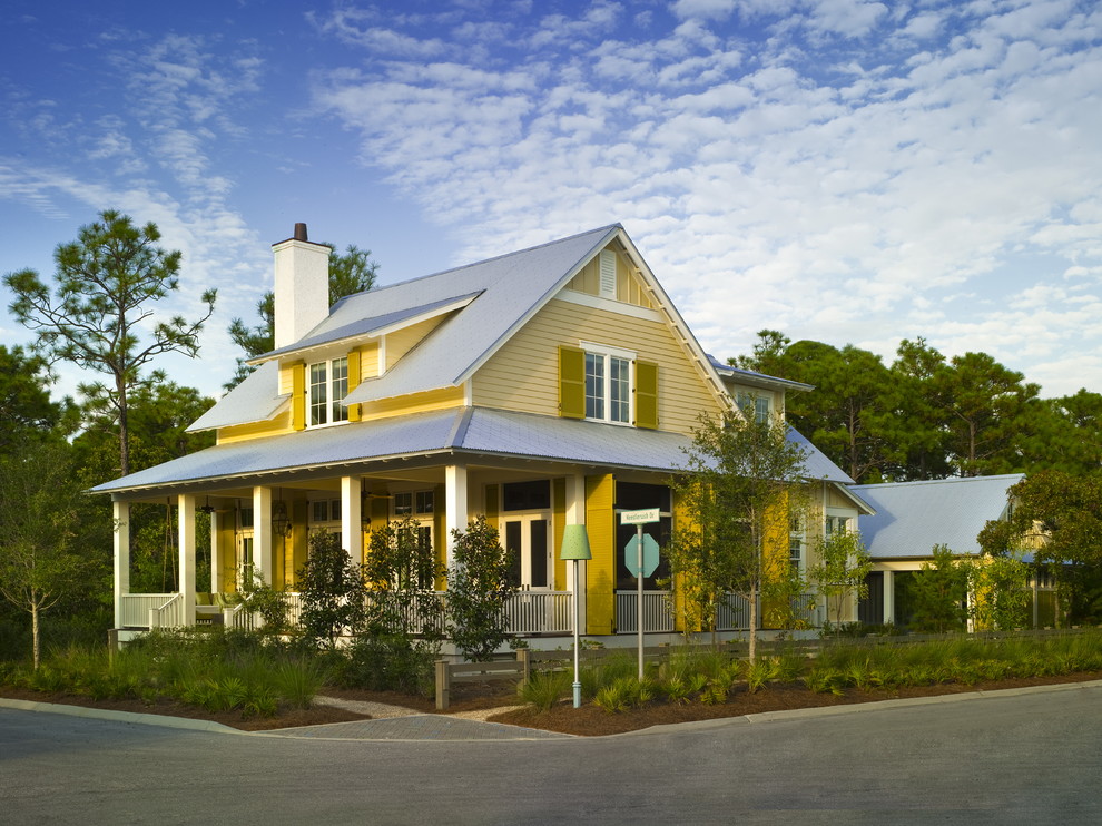 Diseño de fachada amarilla de estilo de casa de campo de dos plantas con tejado a dos aguas