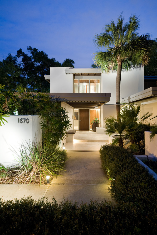 Inspiration for a large mid-century modern white two-story stucco exterior home remodel in Orlando