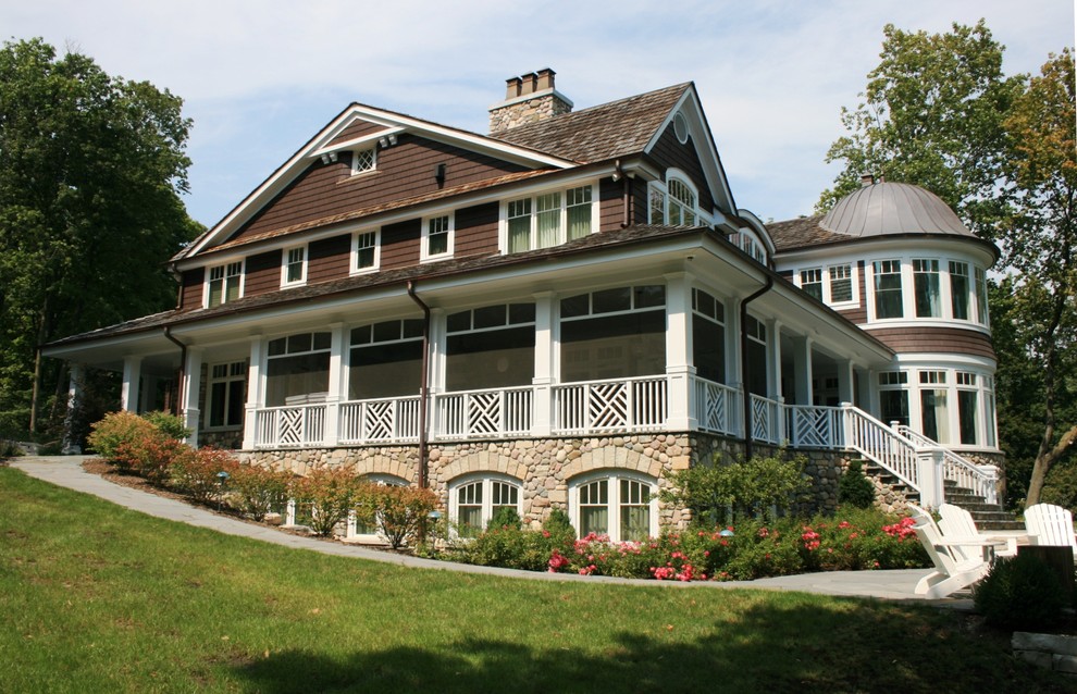 Foto della facciata di una casa grande marrone vittoriana a due piani con rivestimento in pietra, tetto a capanna e copertura mista