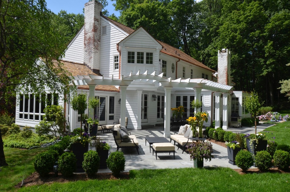 Foto della facciata di una casa bianca classica a due piani di medie dimensioni con rivestimento in legno