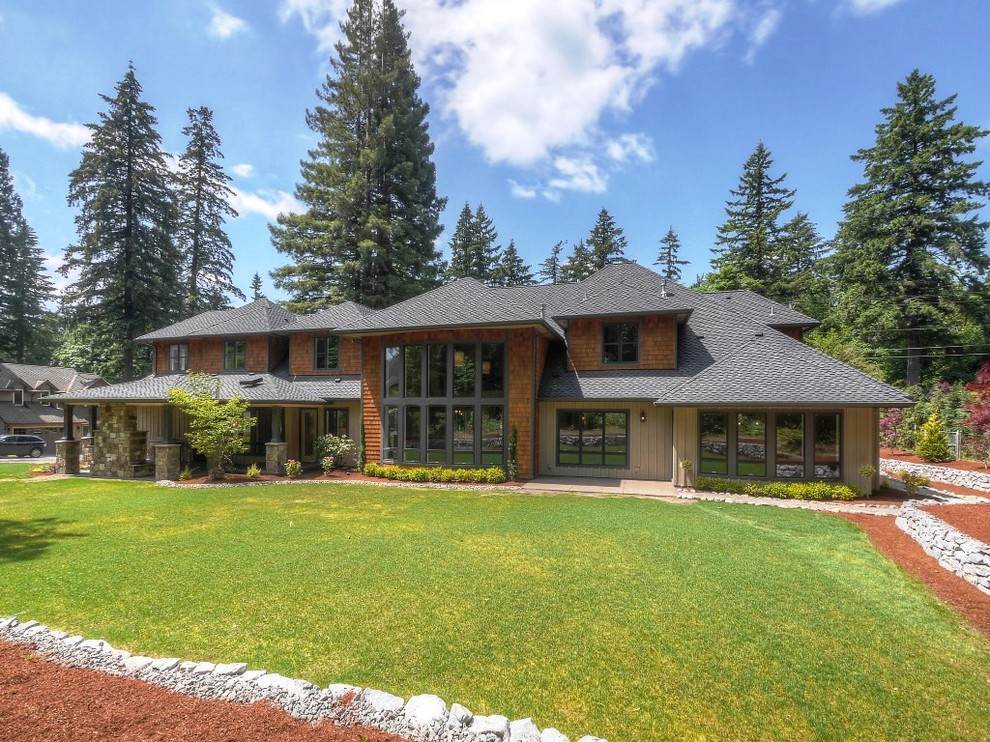 Diseño de fachada de casa beige de estilo americano extra grande de dos plantas con revestimientos combinados y tejado de teja de madera