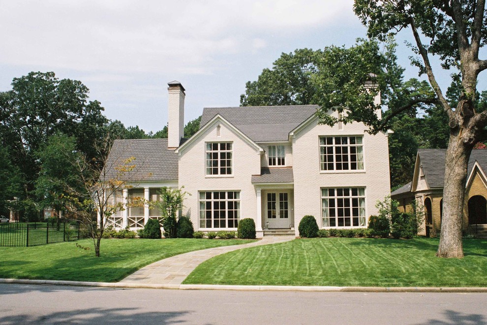 Mid-sized traditional white two-story brick gable roof idea in Little Rock