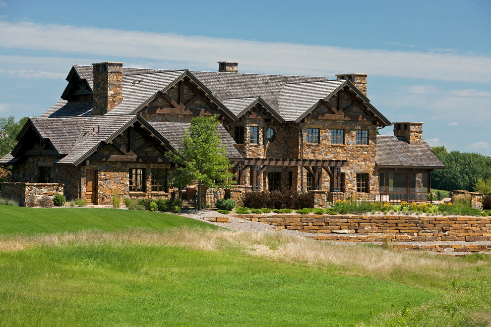 Inspiration for a rustic two floor house exterior in Denver with stone cladding.