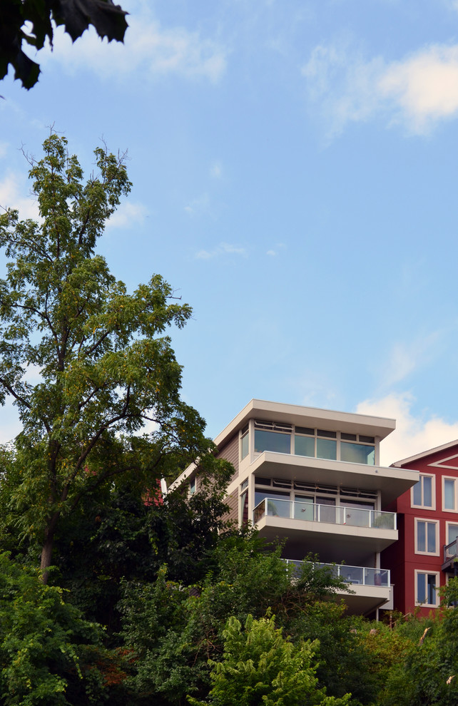 Imagen de fachada beige moderna de tamaño medio de tres plantas con revestimiento de aglomerado de cemento