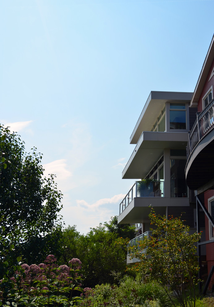 Foto de fachada beige moderna de tamaño medio de tres plantas con revestimiento de aglomerado de cemento