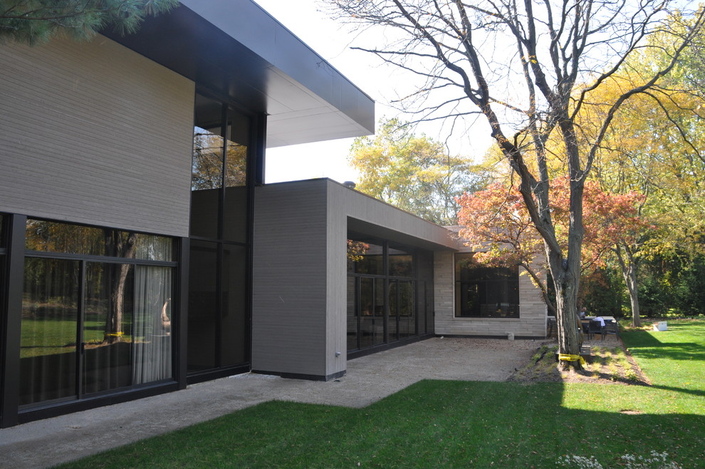 Foto della facciata di una casa ampia contemporanea a due piani con rivestimento in vetro
