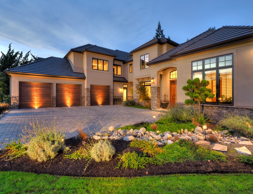 Inspiration for a large mediterranean beige two-story stone house exterior remodel in Seattle with a hip roof and a shingle roof