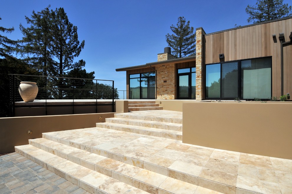Foto della facciata di una casa contemporanea con rivestimento in pietra e abbinamento di colori