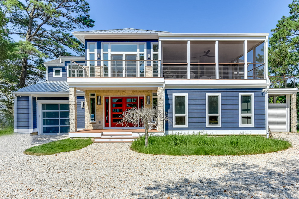 Cette photo montre une très grande façade de maison bleue bord de mer à un étage avec un revêtement en vinyle, un toit à deux pans et un toit en shingle.