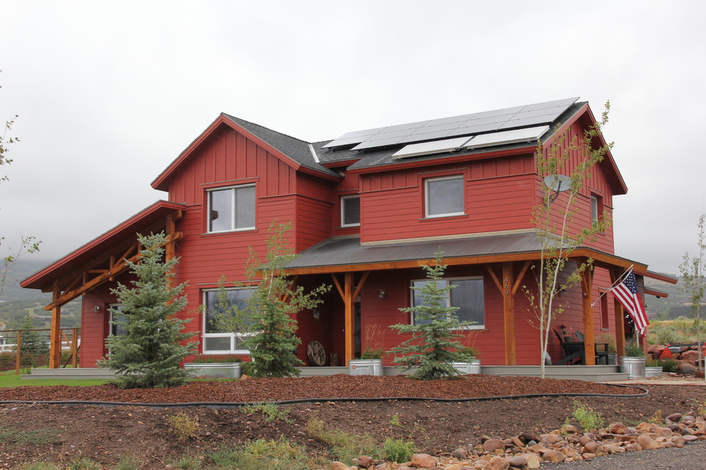 Idée de décoration pour une façade de maison rouge champêtre de taille moyenne et à un étage.